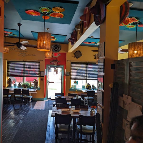 Colorful interior of Tortuga's Mexican Village dining room with tables, chairs, and decorative sombreros.